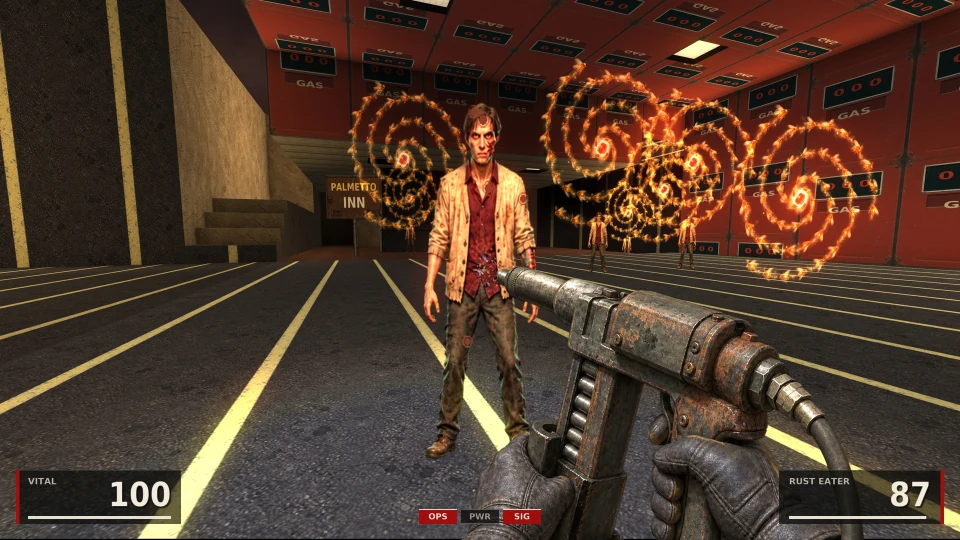 A gas station forecourt with yellow lines and rows of red pumps marked GAS, a Palmetto Inn sign on the left: a wounded man in a beige jacket stands before spirals of fire, other figures behind him; the rusted Rust Eater gun with its hose in hand